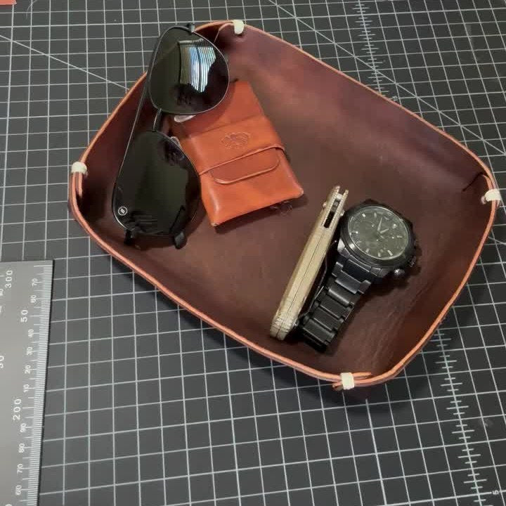 The Stowaway holding a watch, a knife, a card wallet and sunglasses