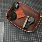 The Stowaway holding a watch, a knife, a card wallet and sunglasses